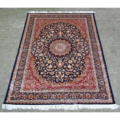 63 - Carpet / Rug : A machine made Keshan carpet, the blue and red ground with stylised floral motiffs. 6... 