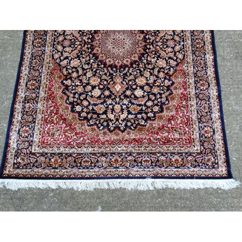 63 - Carpet / Rug : A machine made Keshan carpet, the blue and red ground with stylised floral motiffs. 6... 