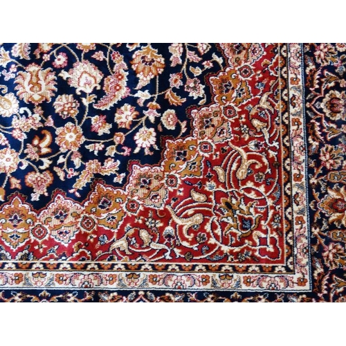 63 - Carpet / Rug : A machine made Keshan carpet, the blue and red ground with stylised floral motiffs. 6... 