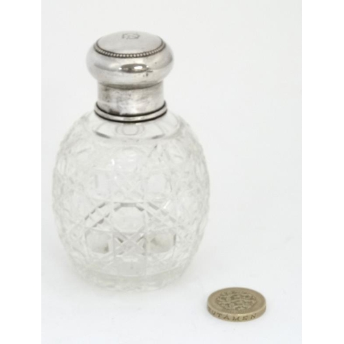 638 - A cut glass scent bottle with silver top. 3 3/4'' high