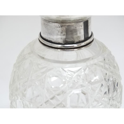 638 - A cut glass scent bottle with silver top. 3 3/4'' high