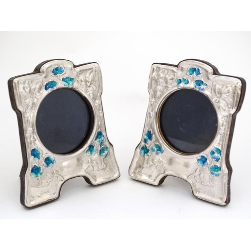 661 - A pair of 21stC photograph frames with silver and enamel decorative surrounds in the Art Nouveau sty... 