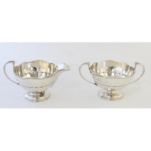 662 - A silver strawberry set comprising sugar bowl and cream jug. Hallmarked London 1911 maker maker Olli... 