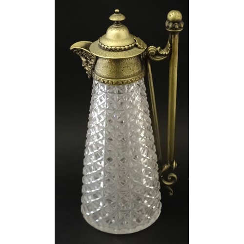 690 - A cut glass claret jug with brass mounts , handle and hinged lid approx 12'' high