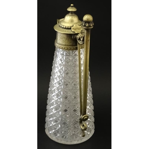 690 - A cut glass claret jug with brass mounts , handle and hinged lid approx 12'' high