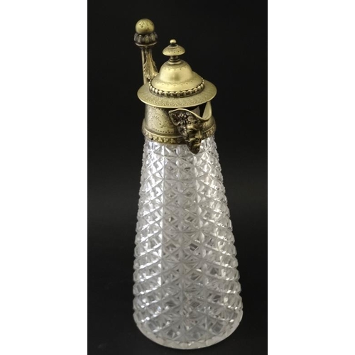 690 - A cut glass claret jug with brass mounts , handle and hinged lid approx 12'' high