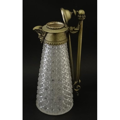 690 - A cut glass claret jug with brass mounts , handle and hinged lid approx 12'' high