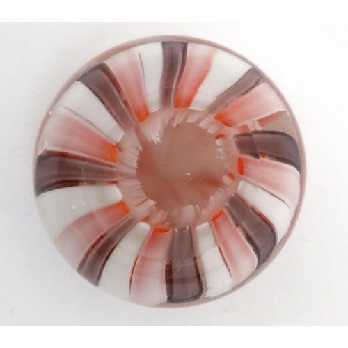 695 - A glass paperweight with banded pink and white decoration approx 3'' diameter