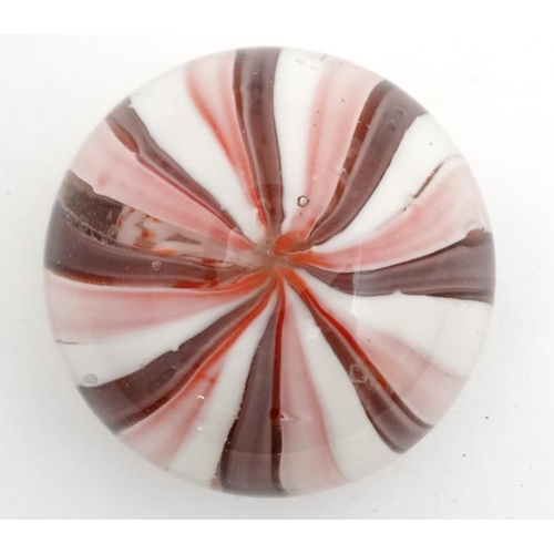 695 - A glass paperweight with banded pink and white decoration approx 3'' diameter