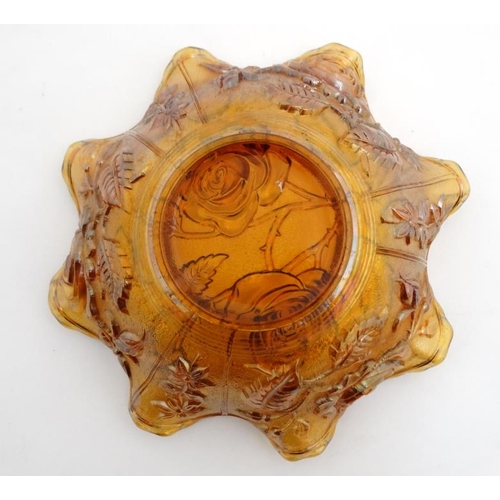 697 - Carnival glass : A Carnival glass bowl with rose pattern and flared rim 9'' diameter