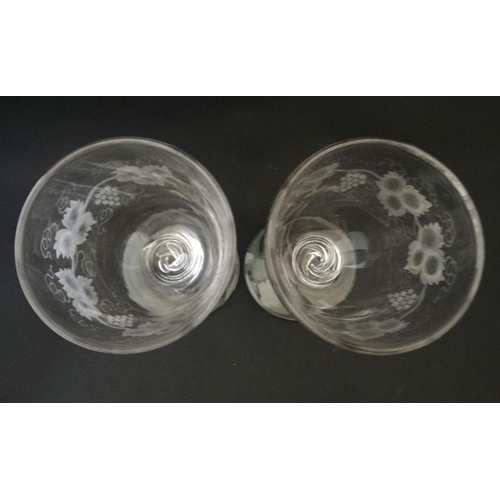 704 - A pair of large pedestal glasses with etched fruiting vine decoration and air twist detail to stems ... 