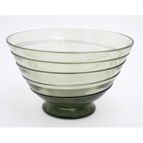 717 - A mid 20thC green glass bowl of stylised conical form with trailed swirl detail and pedestal foot. 7... 