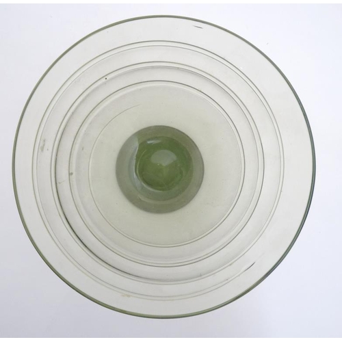 717 - A mid 20thC green glass bowl of stylised conical form with trailed swirl detail and pedestal foot. 7... 