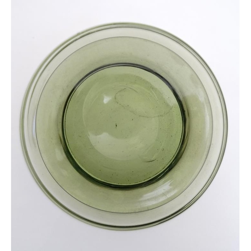 717 - A mid 20thC green glass bowl of stylised conical form with trailed swirl detail and pedestal foot. 7... 