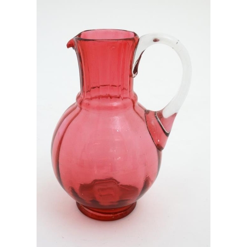 722 - Cranberry Glass : a quantity of glass wares including  2 jugs, bell and a caster. Tallest 6''