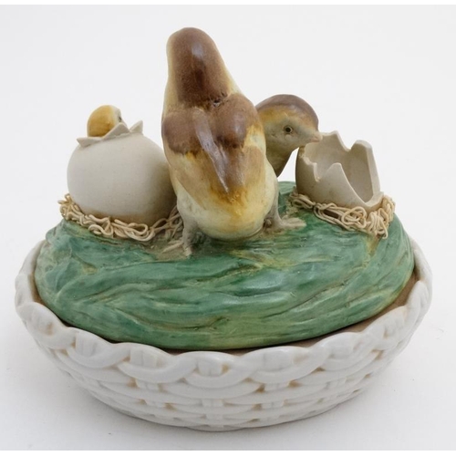 738 - Kitchenalia :   A late 20thC ceramic novelty egg basket and cover, the top decorated with hatching c... 