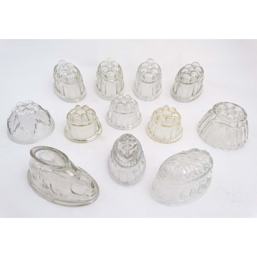 761 - A quantity of assorted glass jelly / blancmange moulds many with lobed decoration, one with anchor d... 