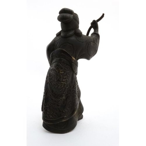 817 - An 18thC / 19thC cast and patinated Oriental bronze figure holding a removable staff. (was possibly ... 