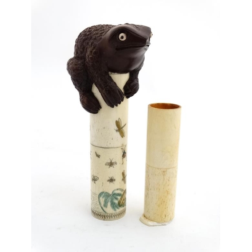 821 - An Oriental bone scroll holder of cylindrical form with shibyama decoration and surmounted by a toad... 