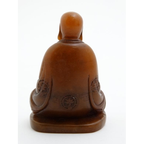 822 - An oriental carved hardstone buddha holding a cylindrical utensil set with many semi precious stone ... 