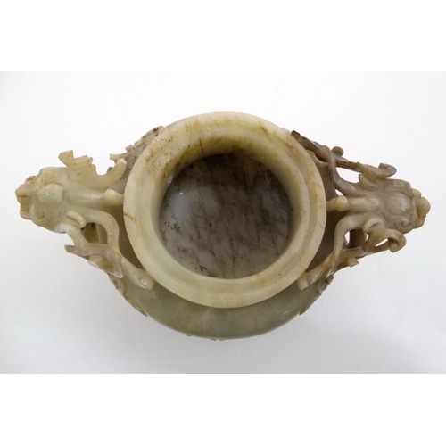 825 - A Jade three footed censor with dragon mask handles and lid with further dragon decoration. The whol... 