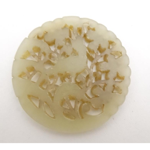 832 - An oriental white jade pierced disc with image of bird amongst prunus 2 1/2'' diameter