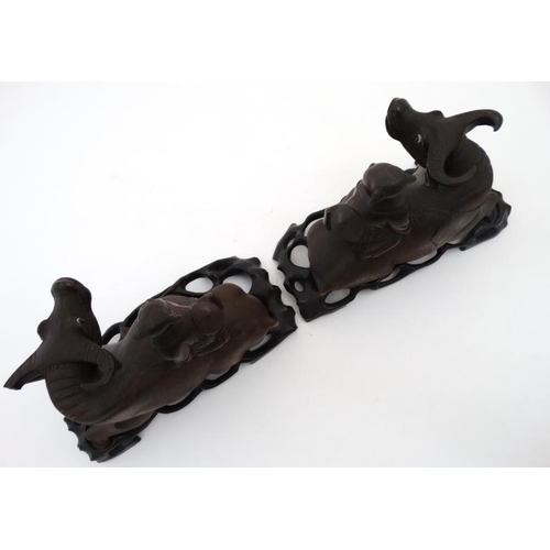 840 - A pair of Chinese carvings formed as children on the backs of water buffaloes on stands , representi... 