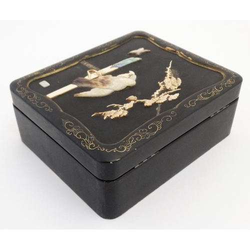 841 - An early 20thC lacquered hinged lidded cabinet with mother of pearl ivory and abalone depicting an e... 