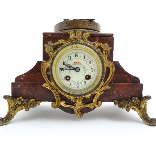 86 - French Clock : a red marble cased mantle clock  with ormolou mounts surmounted by a spelter figure e... 