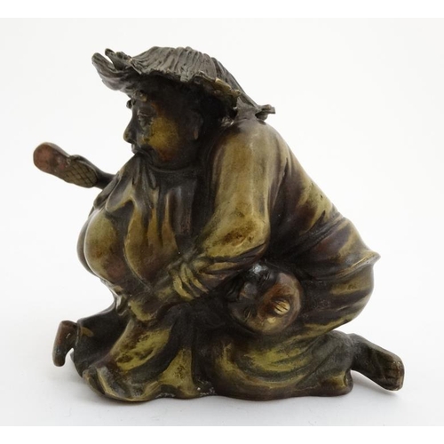 861 - A cast bronze hollow figure of an elder reprimanding a young boy with a shoe. 7'' x 7''