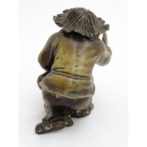 861 - A cast bronze hollow figure of an elder reprimanding a young boy with a shoe. 7'' x 7''