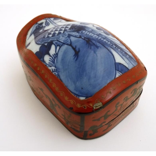 866 - A Chinese shaped red lacquered box and cover with gilt decoration and blue and white ceramic panel w... 