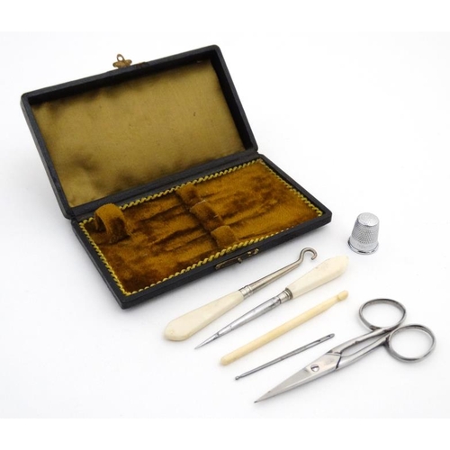 880 - A c.1900 necessaire box opening to reveal a quantity of sewing tools. 5 3/8'' long x 3 1/8'' deep