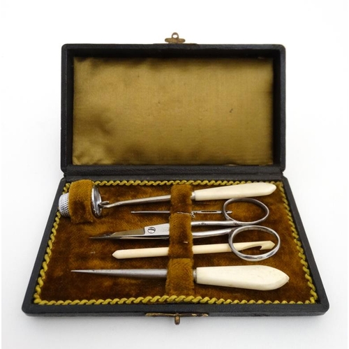 880 - A c.1900 necessaire box opening to reveal a quantity of sewing tools. 5 3/8'' long x 3 1/8'' deep