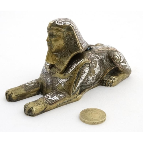 896 - A Victorian desk top inkwell in the form of a sphinx profusely inlaid with copper and silver to the ... 