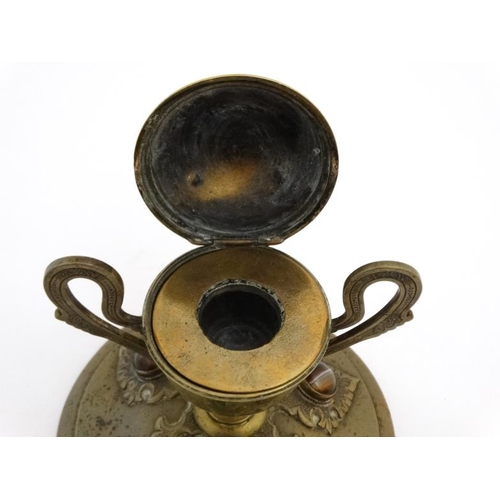 904 - A 19thC brass inkstand with trophy cup style inkwell on circular base and set with 6 banded agate ca... 