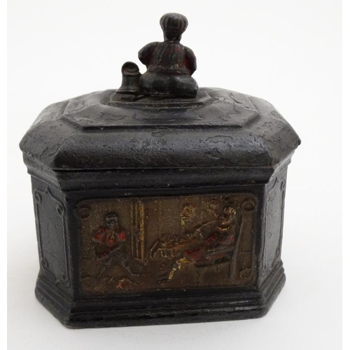 919 - A lead tobacco box and tamper, with polychromed image of a figure smoking with a young Negro man ser... 