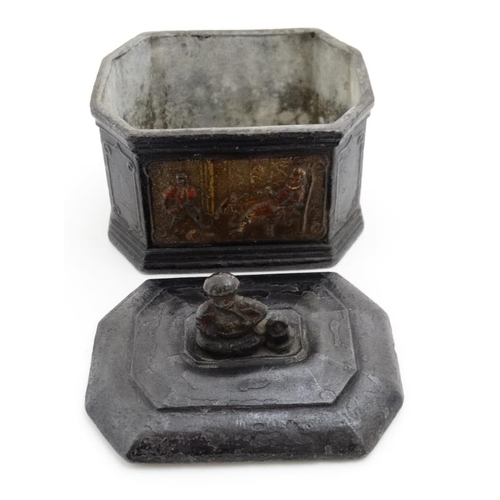 919 - A lead tobacco box and tamper, with polychromed image of a figure smoking with a young Negro man ser... 