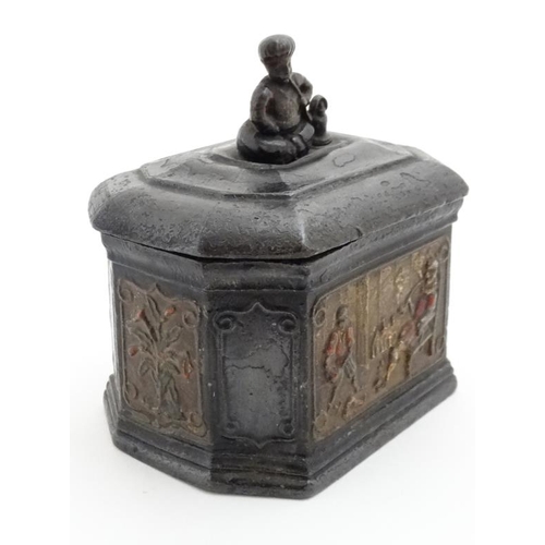 919 - A lead tobacco box and tamper, with polychromed image of a figure smoking with a young Negro man ser... 