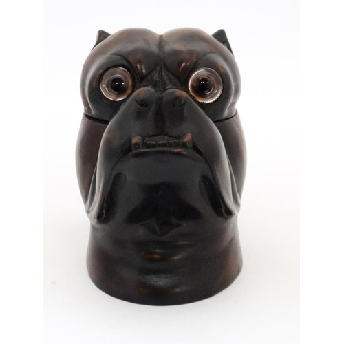 921 - A late 20thC black forest tobacco jar formed as the head of a boxer dog with brass eyes and brass li... 