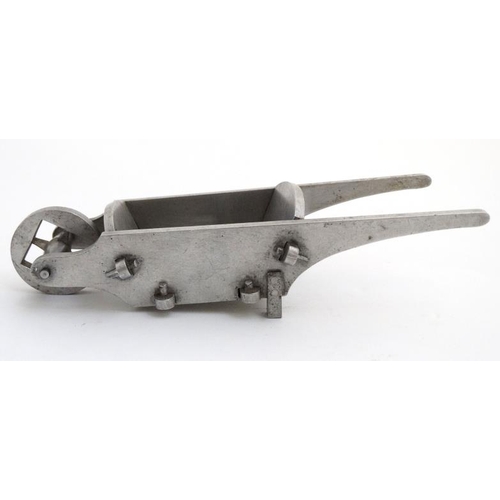 927 - An aluminum model of a garden wheelbarrow with peg joints. 7 1/4'' long