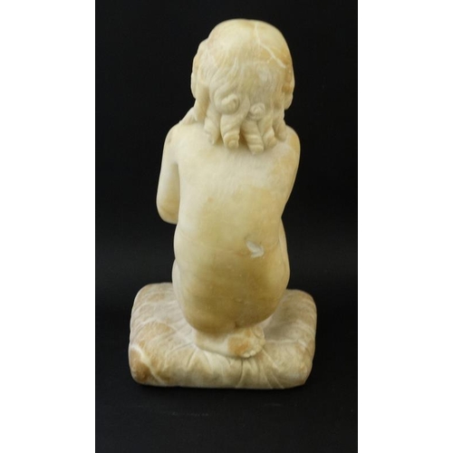 942 - A c.1900 white marble figure of a boy preying on one knee resting upon a squared cushion 14 1/2'' hi... 