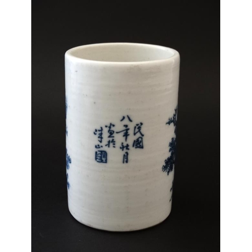 403 - A Chinese blue and white brush pot, decorated with potters at work in a garden scene , bears blue Ch... 