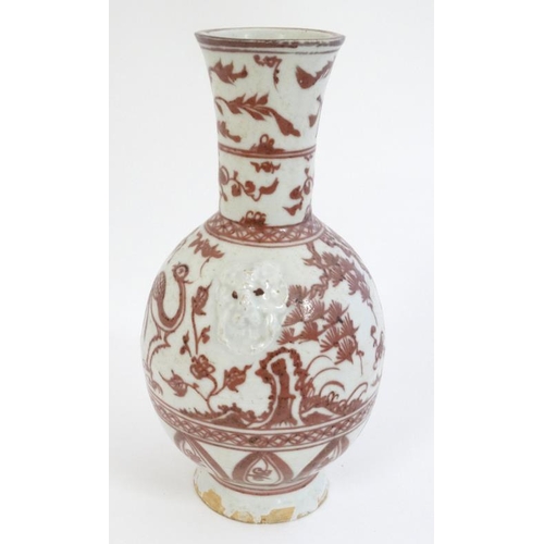 404 - A Chinese iron red and white pottery bottle vase with flared rim , decorated with stylised birds and... 