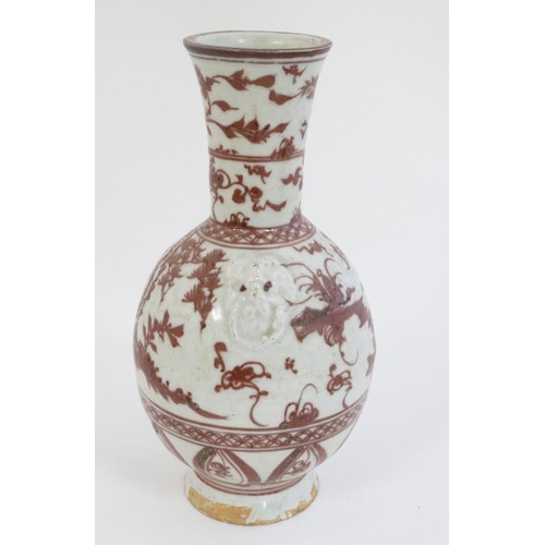 404 - A Chinese iron red and white pottery bottle vase with flared rim , decorated with stylised birds and... 