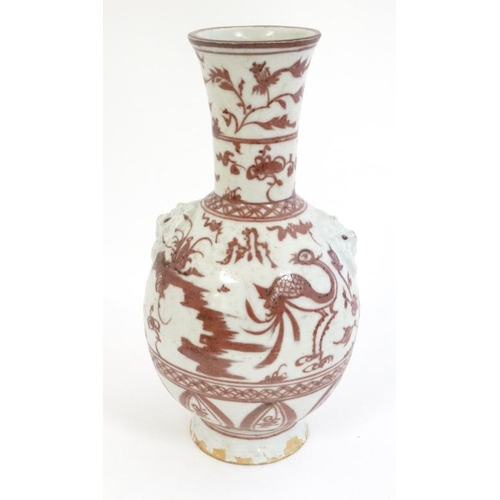 404 - A Chinese iron red and white pottery bottle vase with flared rim , decorated with stylised birds and... 