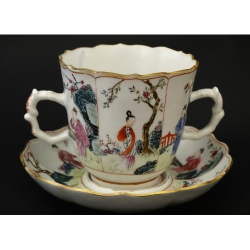 413 - An Oriental famille rose two handled mug and saucer , decorated with panels depicting figures in gar... 