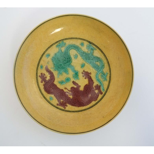 422 - An Imperial yellow  '' dragon '' dish , decorated with two 5 clawed dragons fighting over a flaming ... 