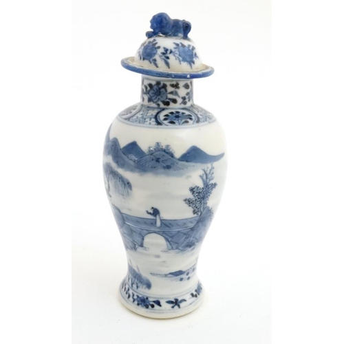 423 - A Chinese blue and white baluster vase and cover, the body decorated with buildings , a bridge and f... 