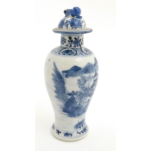 423 - A Chinese blue and white baluster vase and cover, the body decorated with buildings , a bridge and f... 